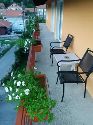 a row of tables and chairs on a patio with flowers at Apartments Mirković in Cetinje