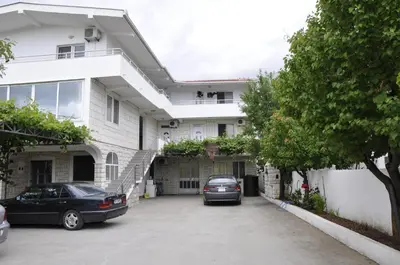 a house with two cars parked in a driveway at Guest House Lalic in Bar