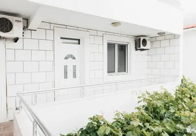 a bathroom with white subway tiles and a plant at Guest House Lalic in Bar