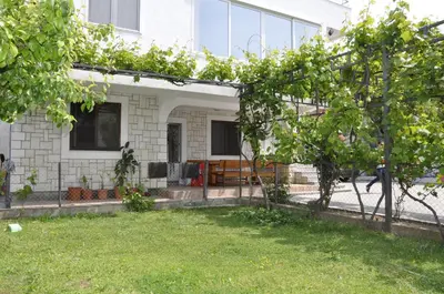 a house with a green yard in front of it at Guest House Lalic in Bar
