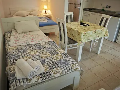 a bedroom with a bed and a table and a table and chairs at Guest House Levant in Čanj