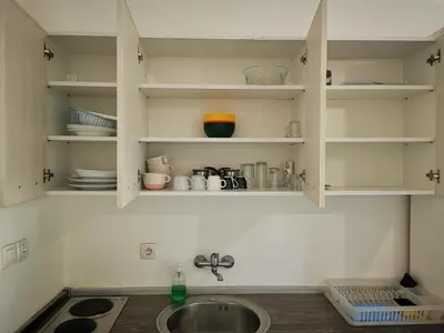 a kitchen with a sink and a counter with shelves at Guest House Levant in Čanj