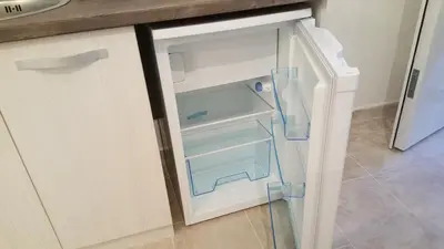 an empty refrigerator with its door open in a kitchen at Guest House Levant in Čanj