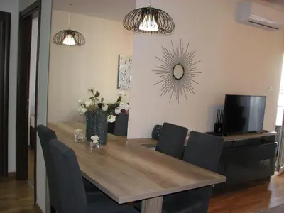 a dining room with a wooden table and chairs at Apartments B&S Lux in Budva