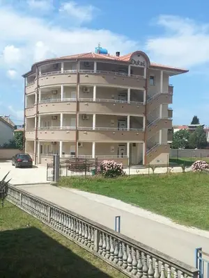 a large apartment building with a road in front of it at Apartments Dukat in Ulcinj