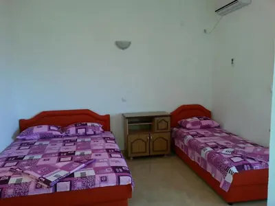 a bedroom with two beds and a night stand at Apartments Dukat in Ulcinj