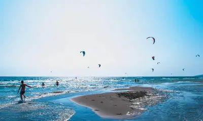 a group of people flying kites on the beach at Apartments Dukat in Ulcinj