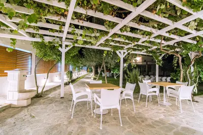 a patio with tables and chairs under a pergola at Jaz Garden Residence in Budva