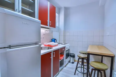 a small kitchen with red cabinets and a counter top at Jaz Garden Residence in Budva