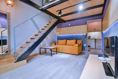 a living room with a couch and a staircase at Jaz Garden Residence in Budva