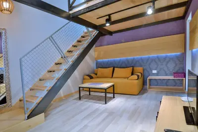 a living room with a couch and a staircase at Jaz Garden Residence in Budva