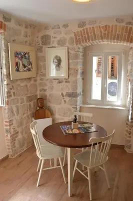 a dining room with a table and chairs at Apartmani Art Karampana in Kotor
