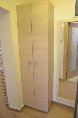 a wooden cabinet in a room with a mirror at Apartmani Art Karampana in Kotor