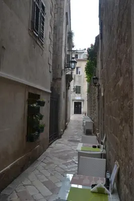 an alley with tables and chairs in an alley at Apartmani Art Karampana in Kotor