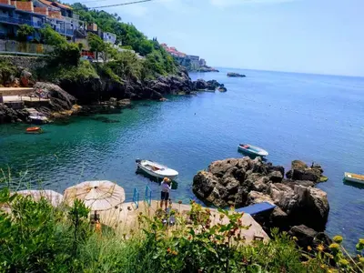 a man standing on the rocks near the water with boats at Apartment Spuza in Ulcinj