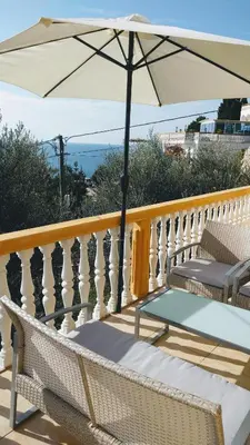 a balcony with a table and an umbrella at Apartment Spuza in Ulcinj