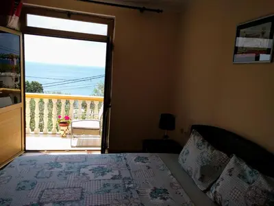 a bedroom with a bed and a door to a balcony at Apartment Spuza in Ulcinj