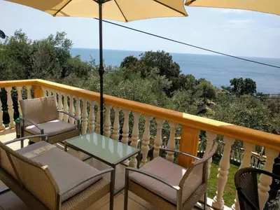 a balcony with chairs and a table and an umbrella at Apartment Spuza in Ulcinj