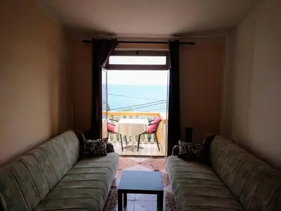 a living room with a couch and a table and a window at Apartment Spuza in Ulcinj