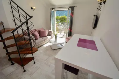 a living room with a spiral staircase and a couch at Apartments House 91 in Kotor