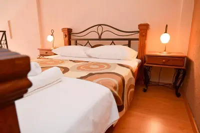 a bedroom with two beds and a table with two lamps at Apartments House 91 in Kotor