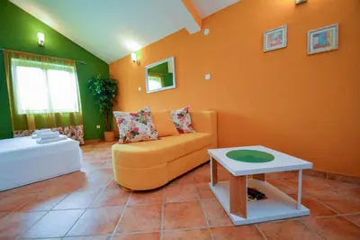 a living room with an orange couch and a table at Apartments House 91 in Kotor
