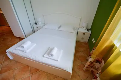 a bedroom with a white bed with towels on it at Apartments House 91 in Kotor