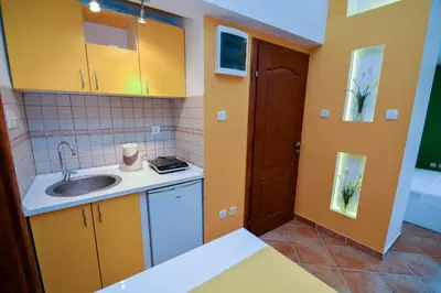 a small kitchen with yellow cabinets and a sink at Apartments House 91 in Kotor