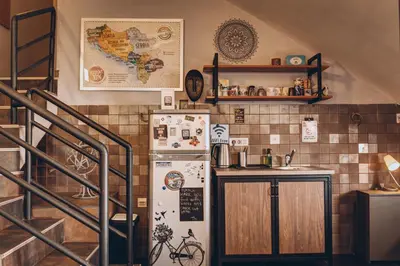 a kitchen with a refrigerator next to a staircase at Q PODGORICA Beds,Rooms and more in Podgorica