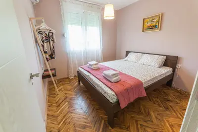 a small bedroom with a bed with a red blanket at Q PODGORICA Beds,Rooms and more in Podgorica