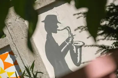 a stencil of a man playing a saxophone on a wall at Q PODGORICA Beds,Rooms and more in Podgorica