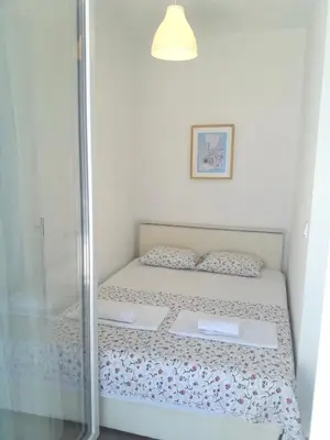 a small bedroom with a bed with a glass door at Two Palms Apartment in Sutomore