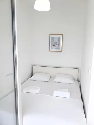 a white bed in a room with a mirror at Two Palms Apartment in Sutomore