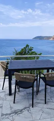a black table and chairs with a view of the ocean at Two Palms Apartment in Sutomore