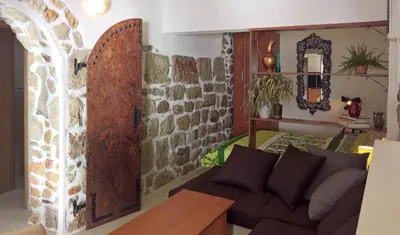 a living room with a couch and a stone wall at Apartments Zezelj in Sveti Stefan
