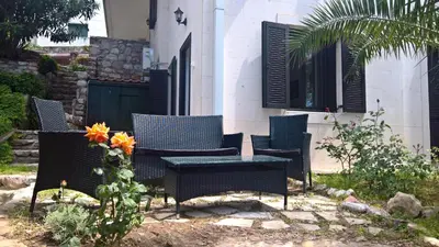 a group of chairs and a table in a yard at Apartments Zezelj in Sveti Stefan
