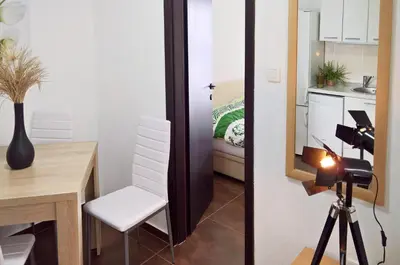 a room with a table and a camera and a kitchen at Apartments Zezelj in Sveti Stefan