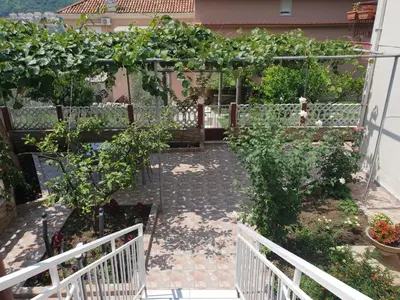 a garden with a pergola and some plants at Badza Apartment in Kotor