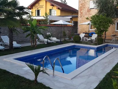 a swimming pool in the backyard of a house at Kazablanka Rooms Aerodrom in Podgorica