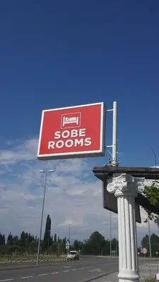 a red and white sign on the side of a road at Kazablanka Rooms Aerodrom in Podgorica
