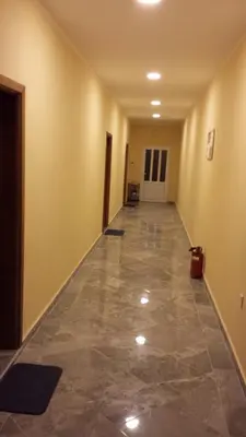 an empty hallway with a tile floor in a building at Kazablanka Rooms Aerodrom in Podgorica