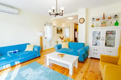 a living room with blue couches and a white table at 