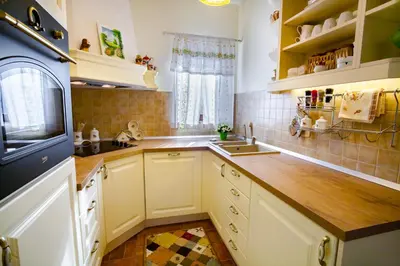a kitchen with white cabinets and a wooden counter top at 