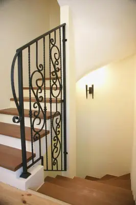 a stairway with a black iron railing at 