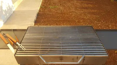 a metal bench sitting on the side of a sidewalk at Apartments Diva in Dobra Voda