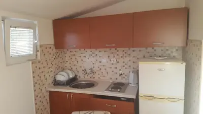 a small kitchen with a sink and a refrigerator at Apartments Diva in Dobra Voda