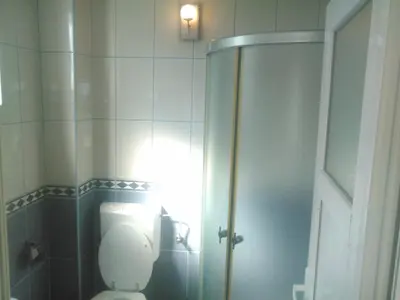 a bathroom with a toilet and a light on the wall at Apartmani Pikula in Sutomore