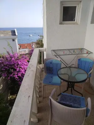 a balcony with a table and chairs and the ocean at Apartmani Pikula in Sutomore
