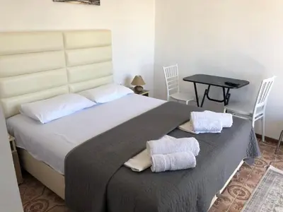a bedroom with a large bed with two towels on it at Rejhan TOTTI in Ulcinj