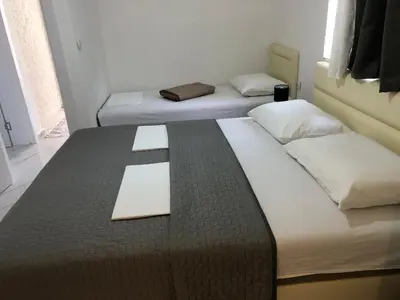 two beds in a small room with a paper on top at Rejhan TOTTI in Ulcinj